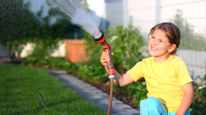Mädchen beim Bewässern mit Regenwasser